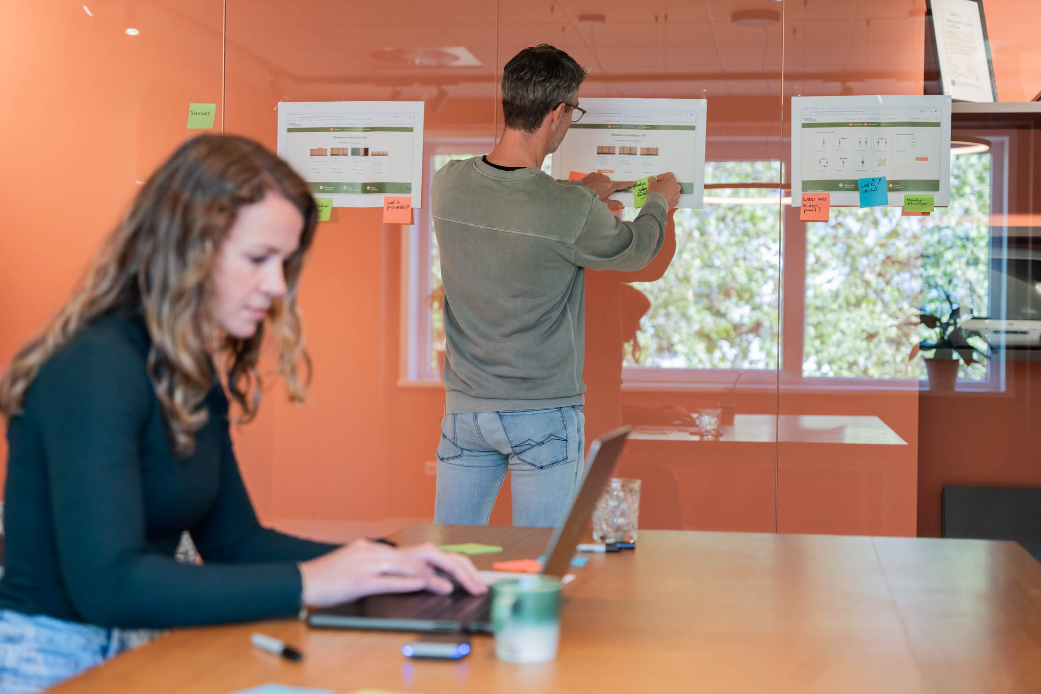 Onderzoekers die bevindingen bespreken bij het bord met printouts en sticky notes